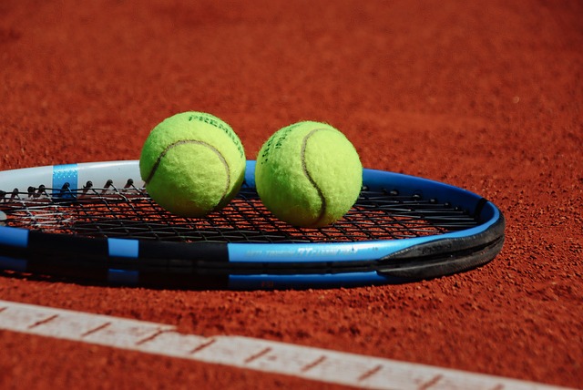 Foto racchetta da tennis su cui sono appoggiate 2 palline da tennis
